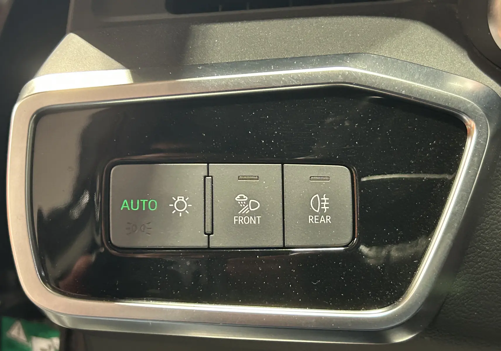 Boutons de commande des phares avant et arrière sur le tableau de bord noir d'une Audi A6 Avant 40 TDI 2019.