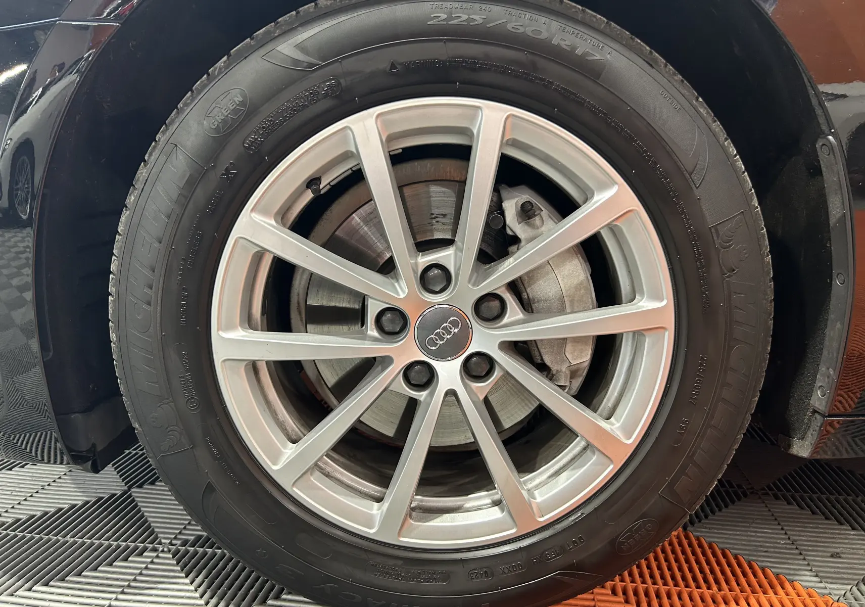 Gros plan sur la roue avant droite noire d'une Audi A6 Avant 40 TDI 2019 avec jante alliage et logo Audi central.