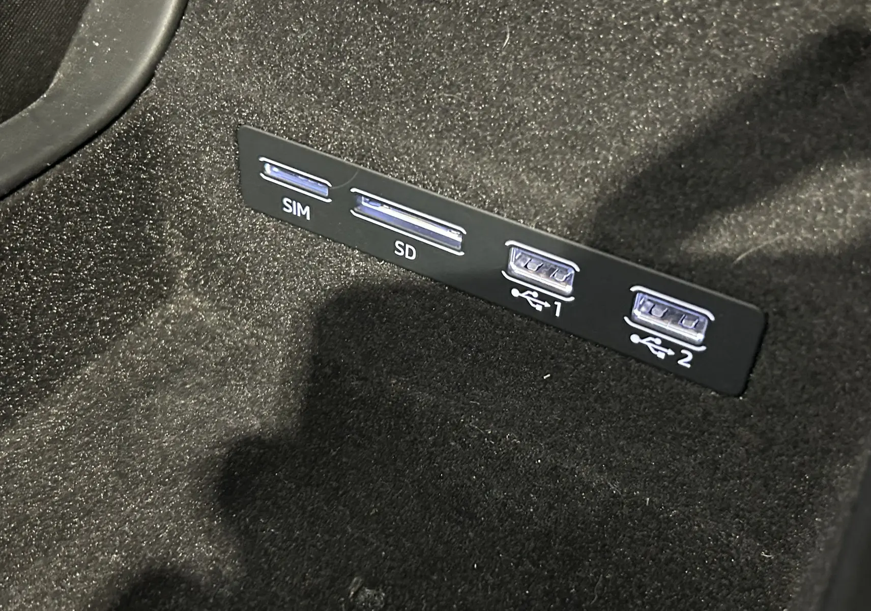 Gros plan sur les ports SIM, SD et USB dans l'habitacle noir de l'Audi A6 Avant 40 TDI 2019.