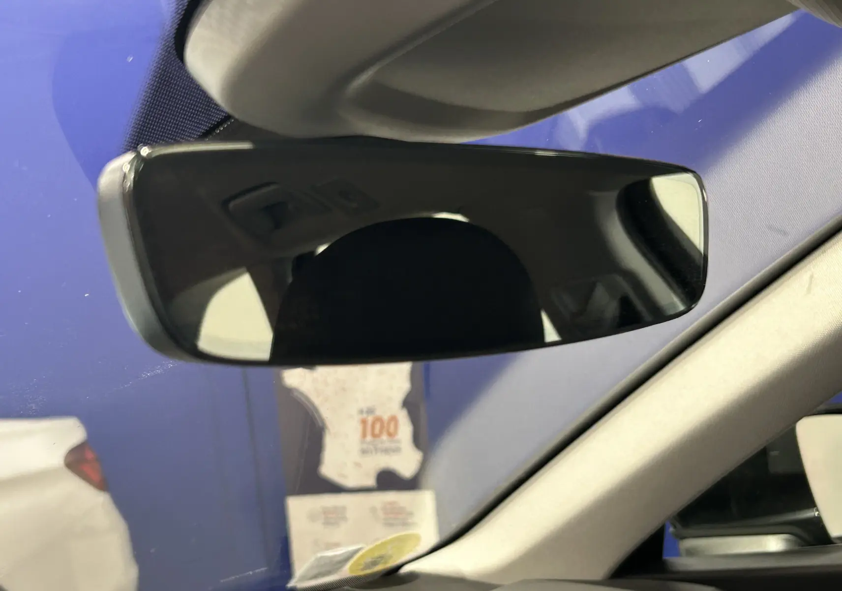 Rétroviseur intérieur de l'Audi A6 Avant 40 TDI 2019 avec partie de l'habitacle beige visible et pare-brise bleu en arrière-plan.