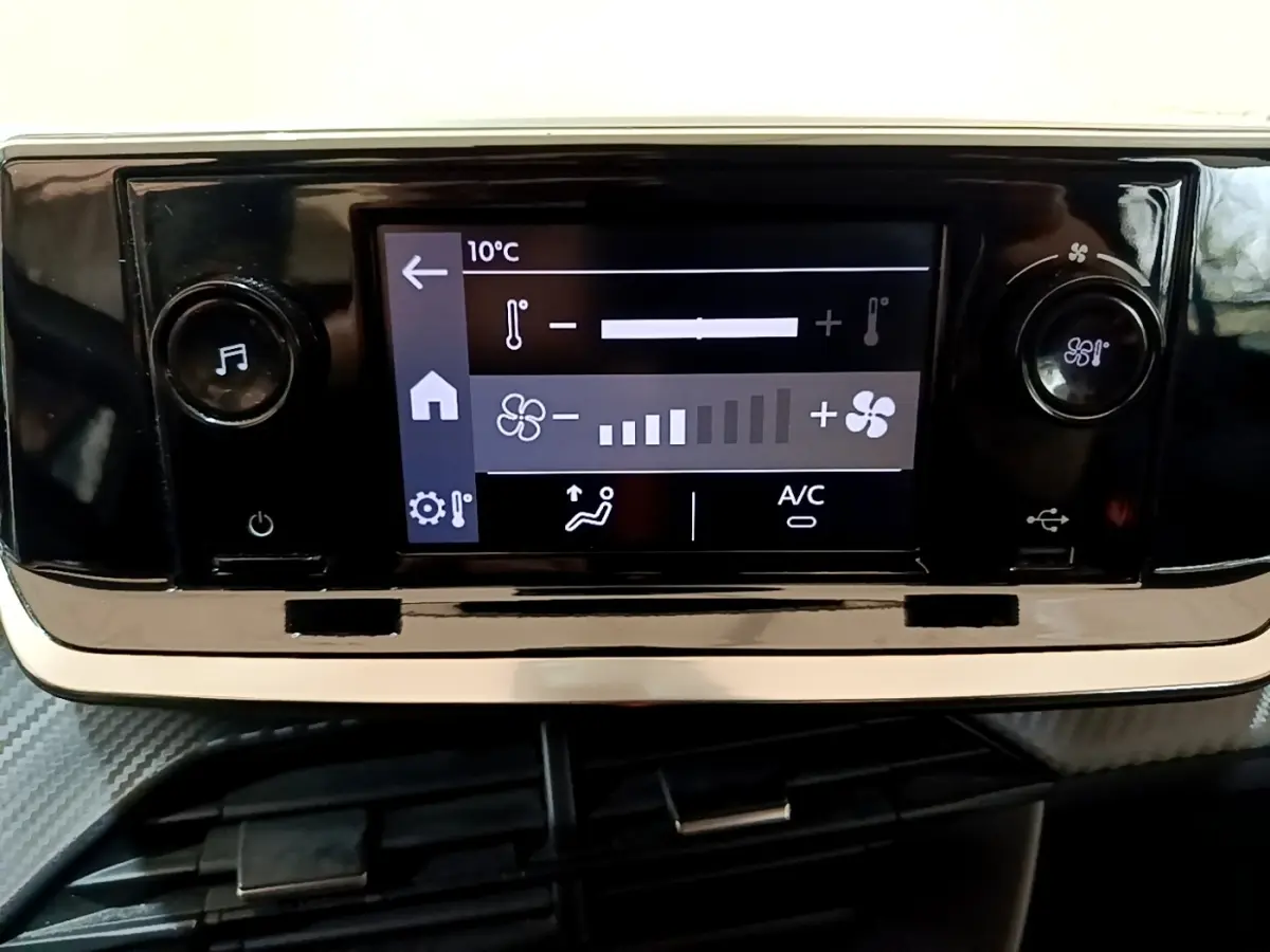 Écran tactile central de la Peugeot 208 blanc 2022 affichant la climatisation à 10°C avec commandes rotatives.