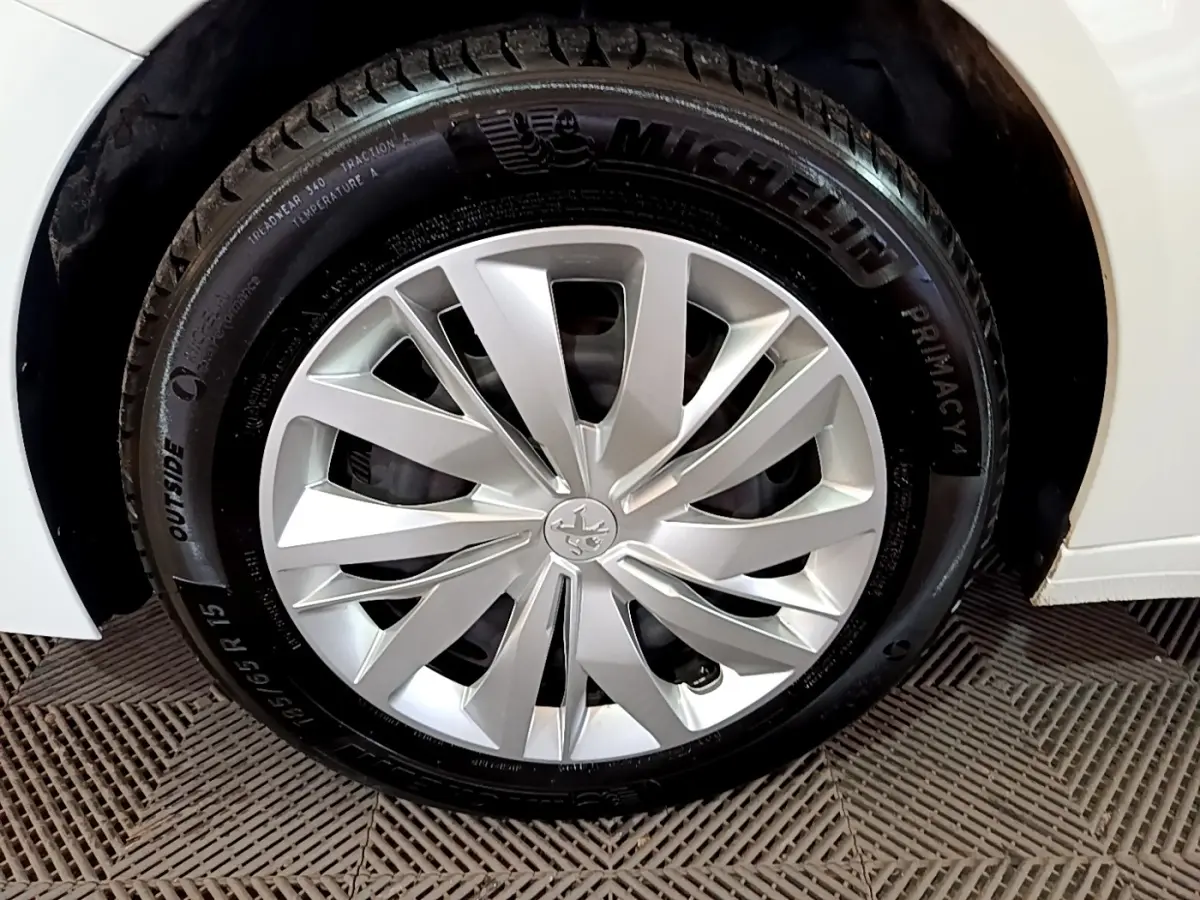 Gros plan sur la roue avant droite blanche d'une Peugeot 208 1.5 BlueHDi 100 avec jante en alliage et pneu Michelin.