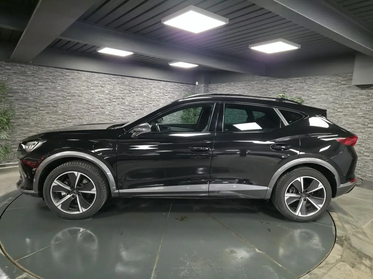 Vue de profil côté gauche du CUPRA Formentor noir avec jantes alliage et détails gris contrastants sur les bas de caisse.