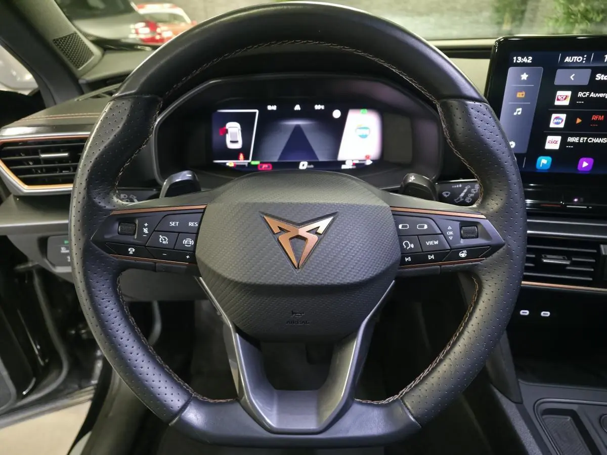 Vue rapprochée du volant sport noir avec logo cuivre et tableau de bord digital du CUPRA Formentor 1.4 e-Hybrid 2023.