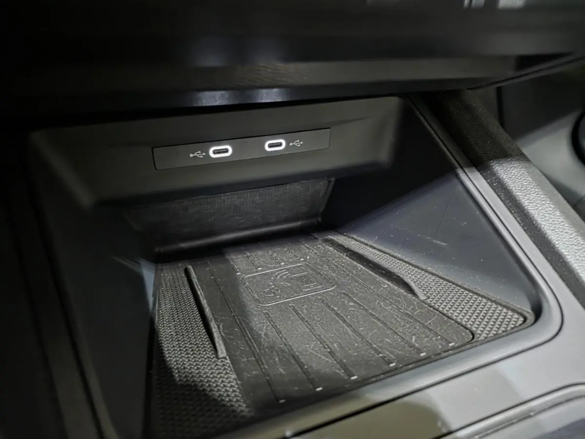 Gros plan sur la console centrale noire du CUPRA Formentor 2023, montrant deux prises USB-C éclairées et un tapis de recharge sans fil.