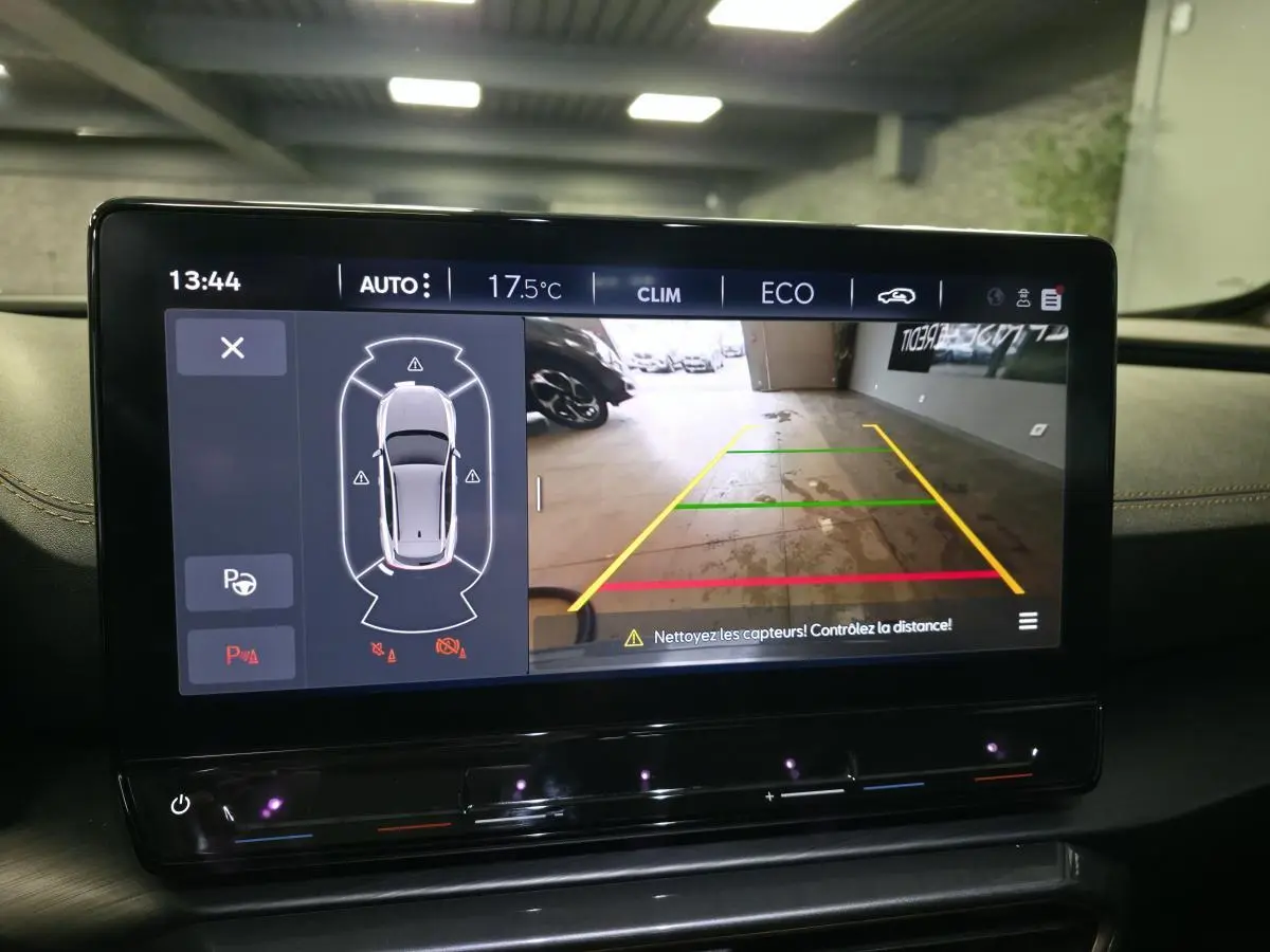 Écran tactile intérieur affichant la caméra de recul et l’aide au stationnement du CUPRA Formentor noir, vue de face.