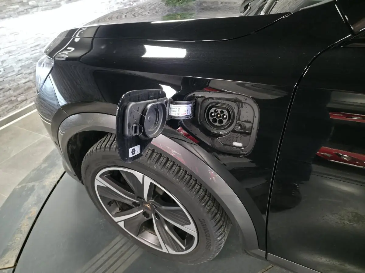 Prise de recharge ouverte côté avant gauche sur CUPRA Formentor noir, avec jante alliage 18 pouces visible.