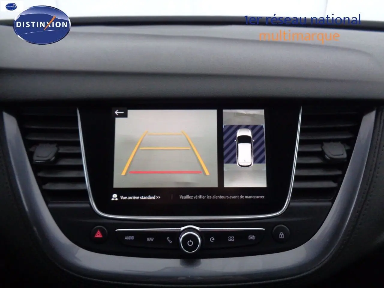 Écran central de l’Opel Grandland X blanc nacré montrant la caméra de recul et l’aide au stationnement en vue arrière.