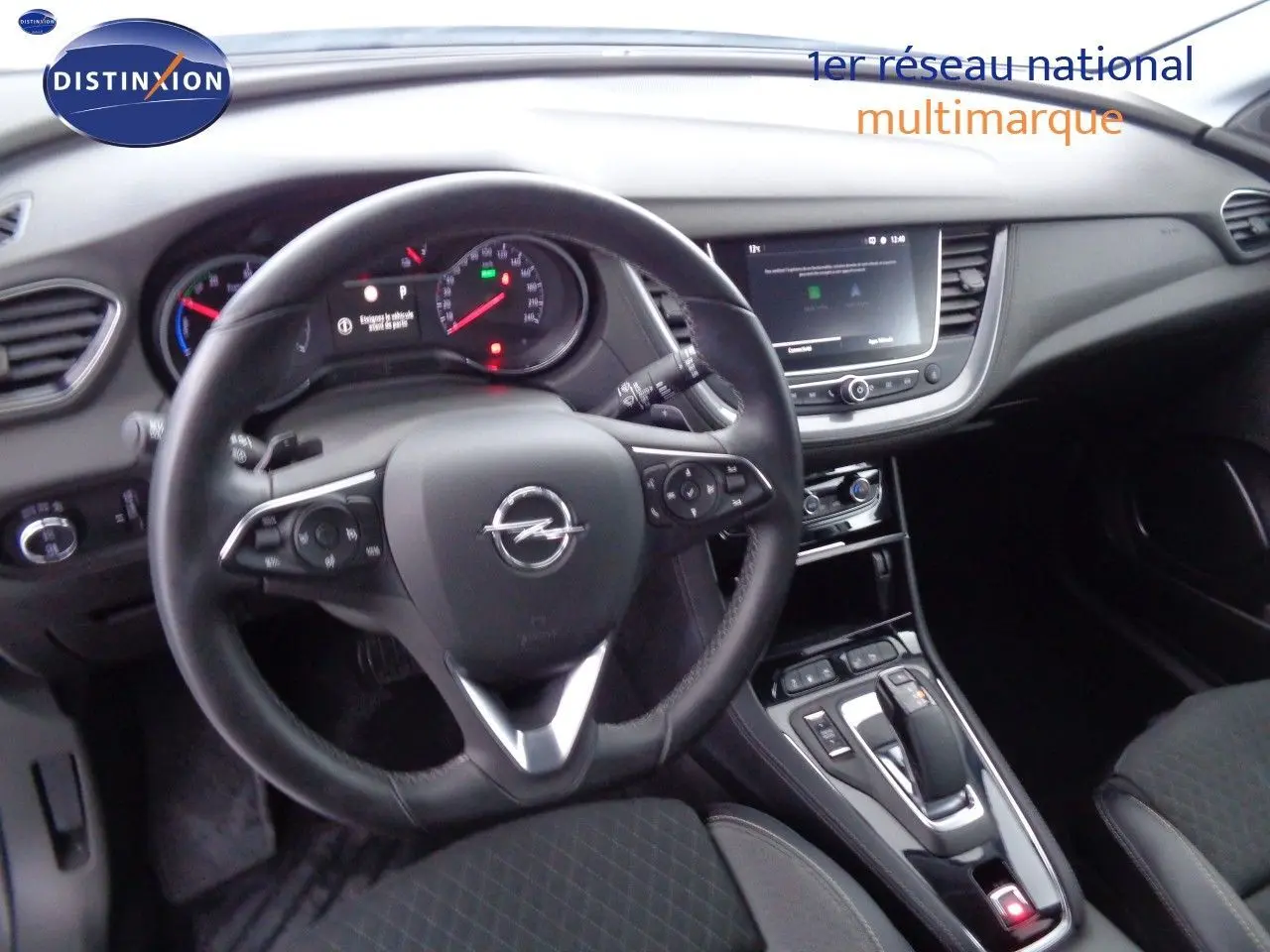 Vue intérieure de l'Opel Grandland X 1.6 Hybrid Turbo 2021, tableau de bord et volant noir avec console centrale moderne.