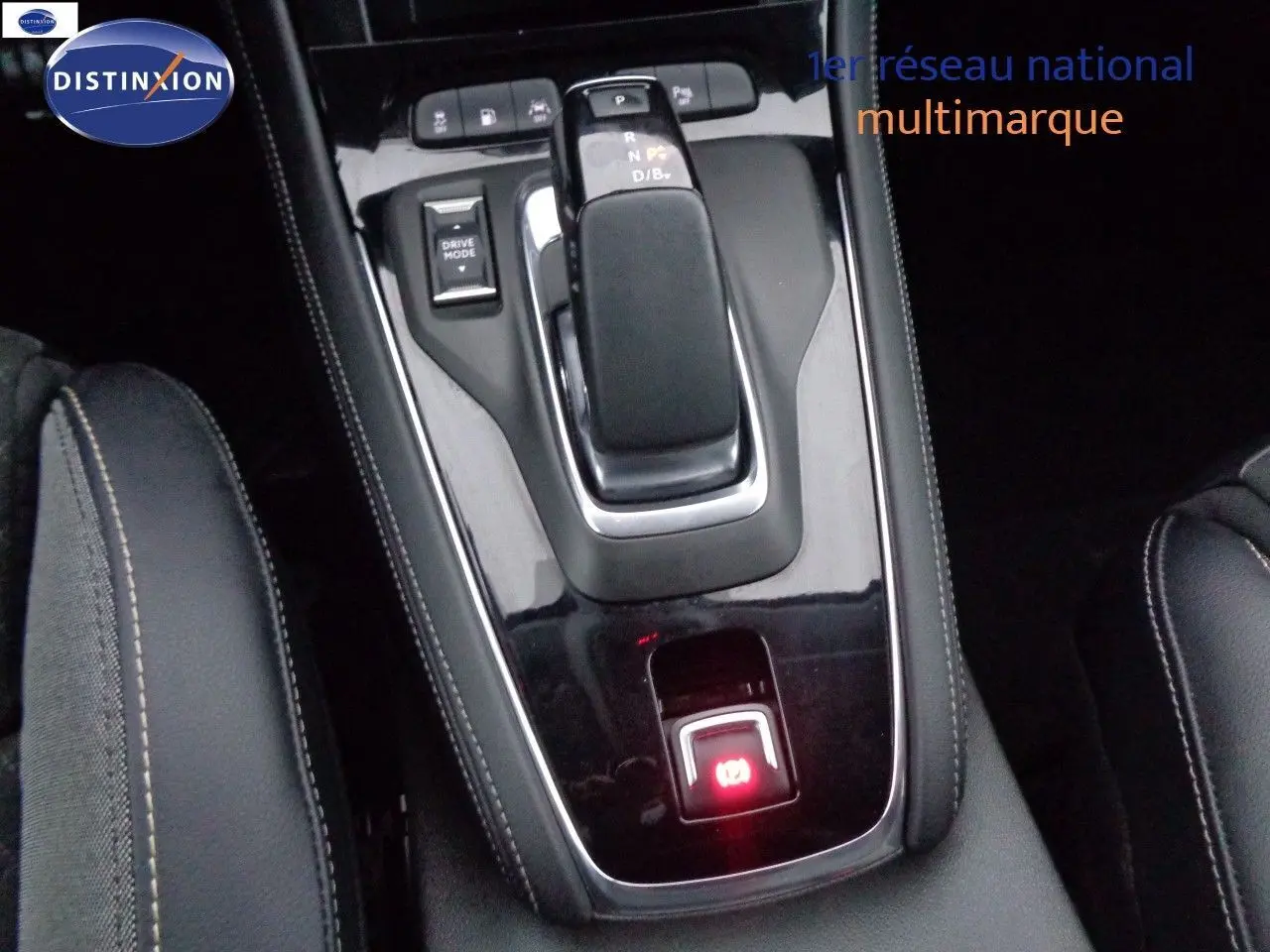 Vue rapprochée de la console centrale noire du Opel Grandland X hybride, avec levier de vitesse automatique et bouton Drive Mode.