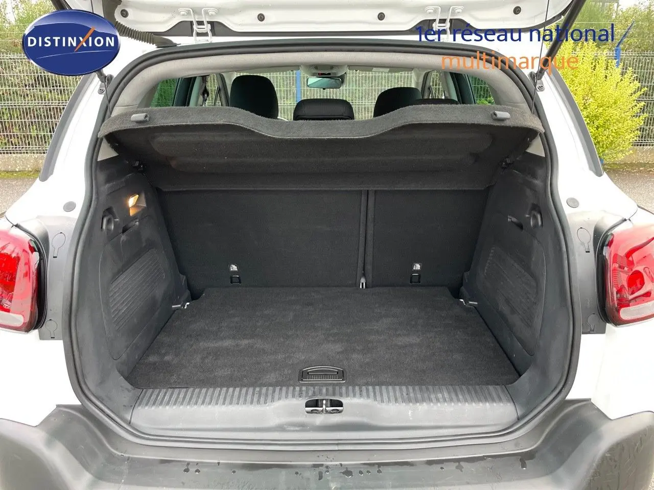 Coffre ouvert vu de l'arrière d'un Citroën C3 Aircross blanc polaire, montrant un espace de chargement propre et spacieux.