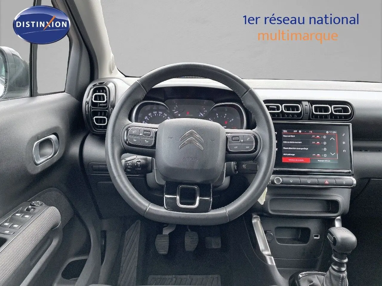 Vue centrée sur le volant et le tableau de bord du Citroën C3 Aircross 2023 avec écran tactile et commandes au volant.
