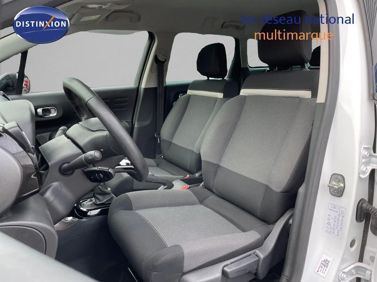 Intérieur du Citroën C3 Aircross blanc polaire 2023, vue côté conducteur sur les sièges tissu gris et noir.