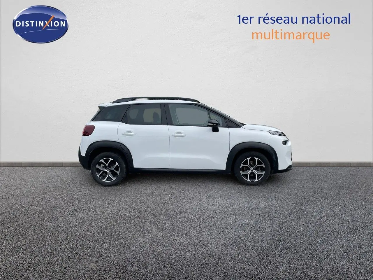 Profil côté gauche d'un Citroën C3 Aircross blanc polaire avec toit noir et jantes alliage bicolores.