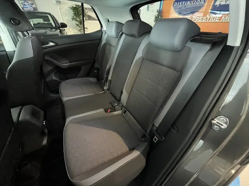 Vue intérieure côté droit des sièges arrière gris foncé et clair du Volkswagen T-Cross 2021 dans un showroom.
