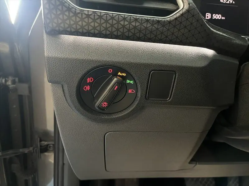 Gros plan sur le sélecteur de phares du tableau de bord d'un Volkswagen T-Cross gris Limestone métalisé, côté gauche.