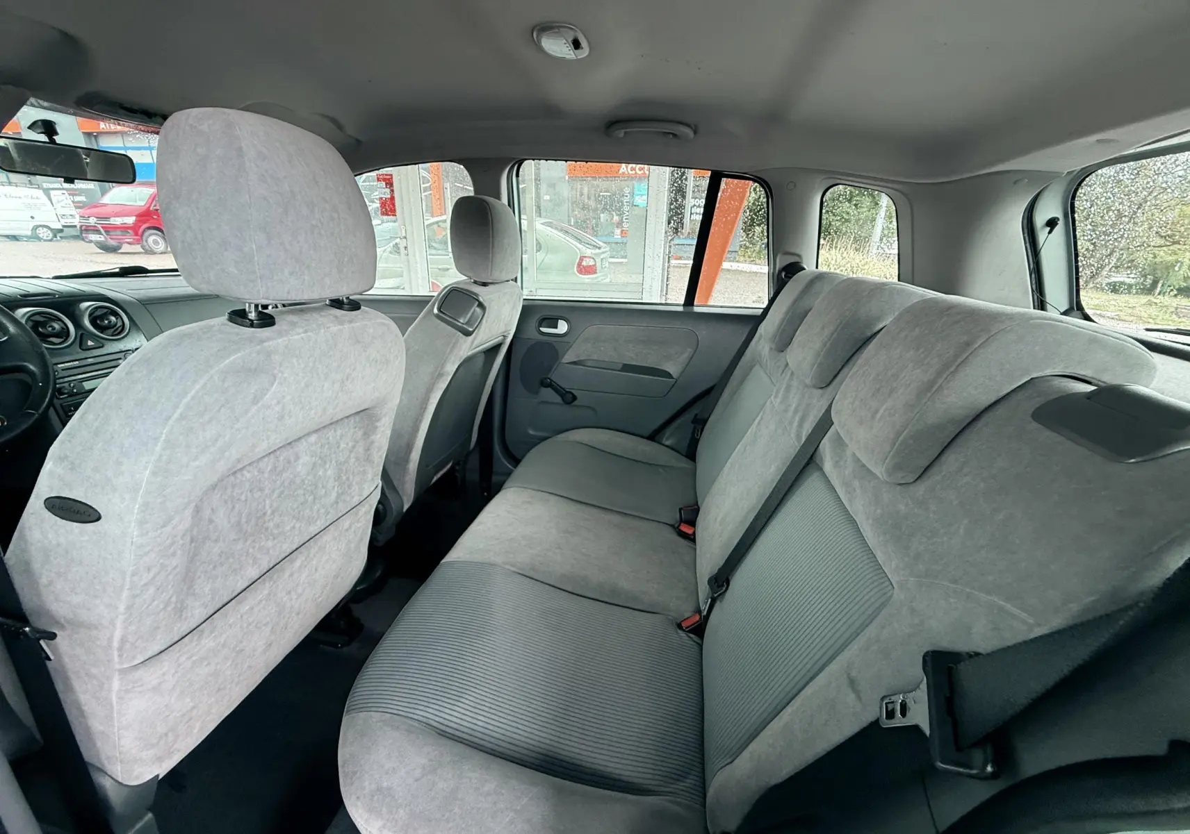 Vue intérieure côté droit montrant la banquette arrière grise et les sièges avant d'une Ford Fusion 2002.