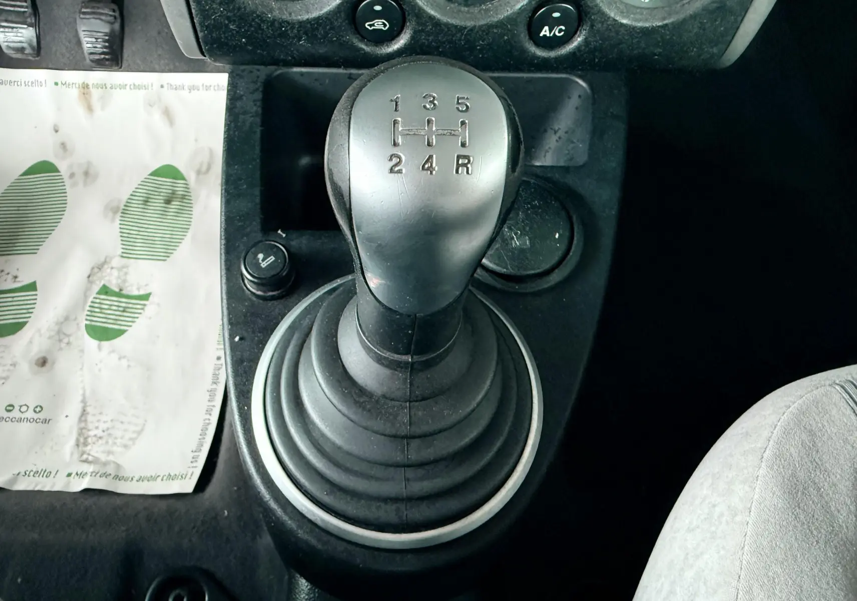 Le levier de vitesse manuel de la Ford Fusion 2002 en gros plan, entouré de commandes et siège gris visible.