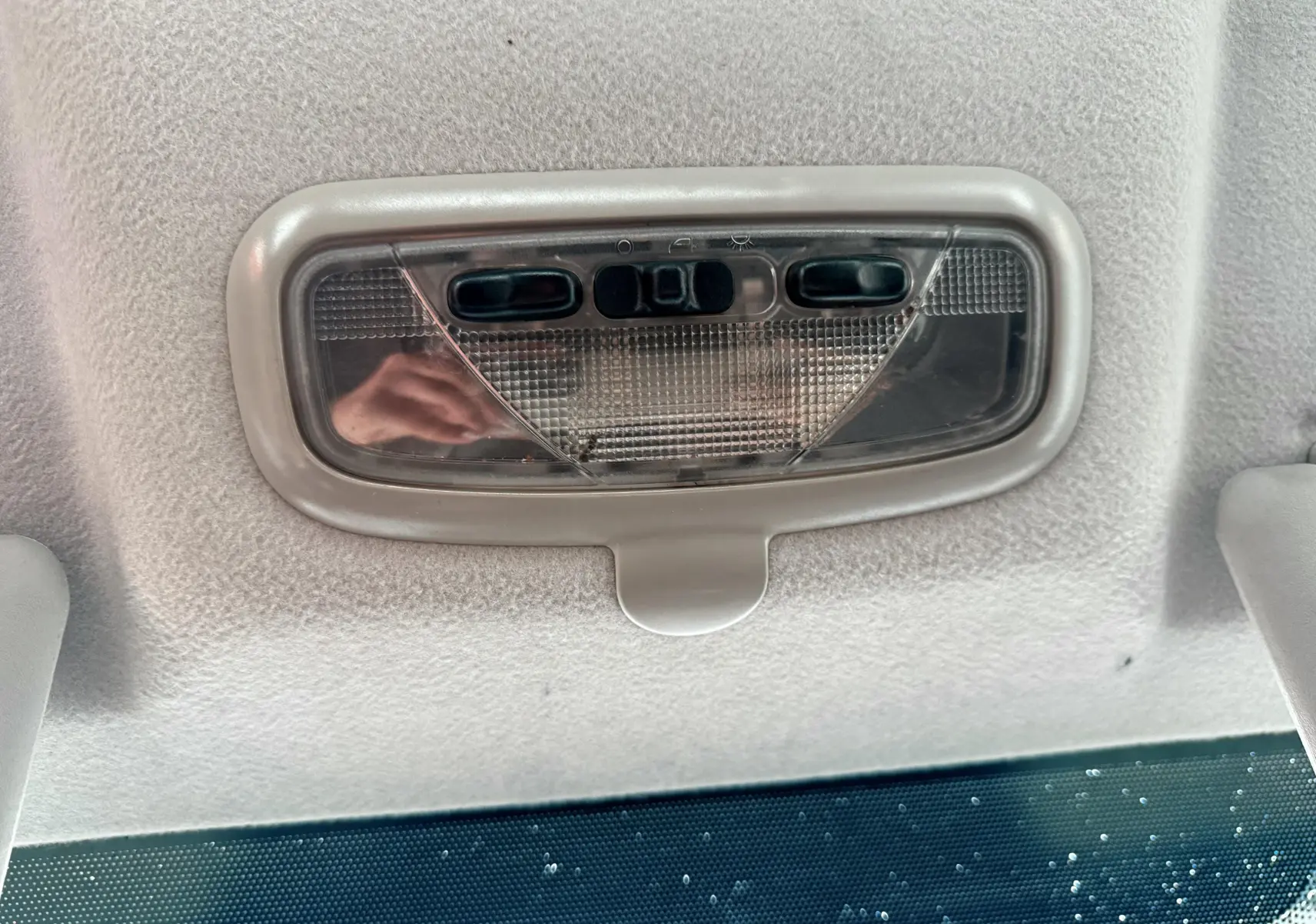 Plafonnier intérieur gris clair de la Ford Fusion 2002 visible au-dessus du pare-brise avec boutons de commande intégrés.