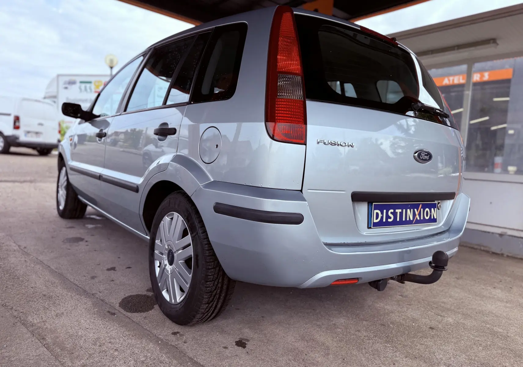 Vue 3/4 arrière droite d'une Ford Fusion bleu clair de 2002 avec attelage et hayon fermé.