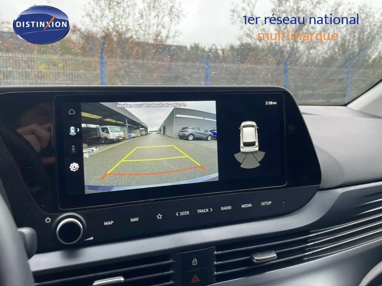 Vue intérieure sur l’écran multimédia affichant la caméra de recul avec lignes de guidage dans une Hyundai i20 gris Aurora.