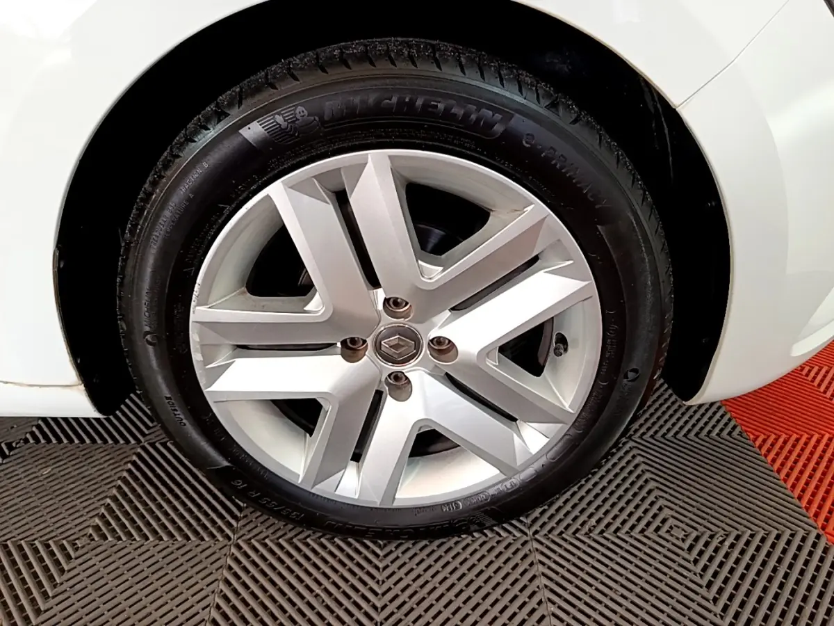 Gros plan sur la roue avant droite d'une Renault Clio blanche, mettant en valeur la jante alliage et le pneu Michelin.