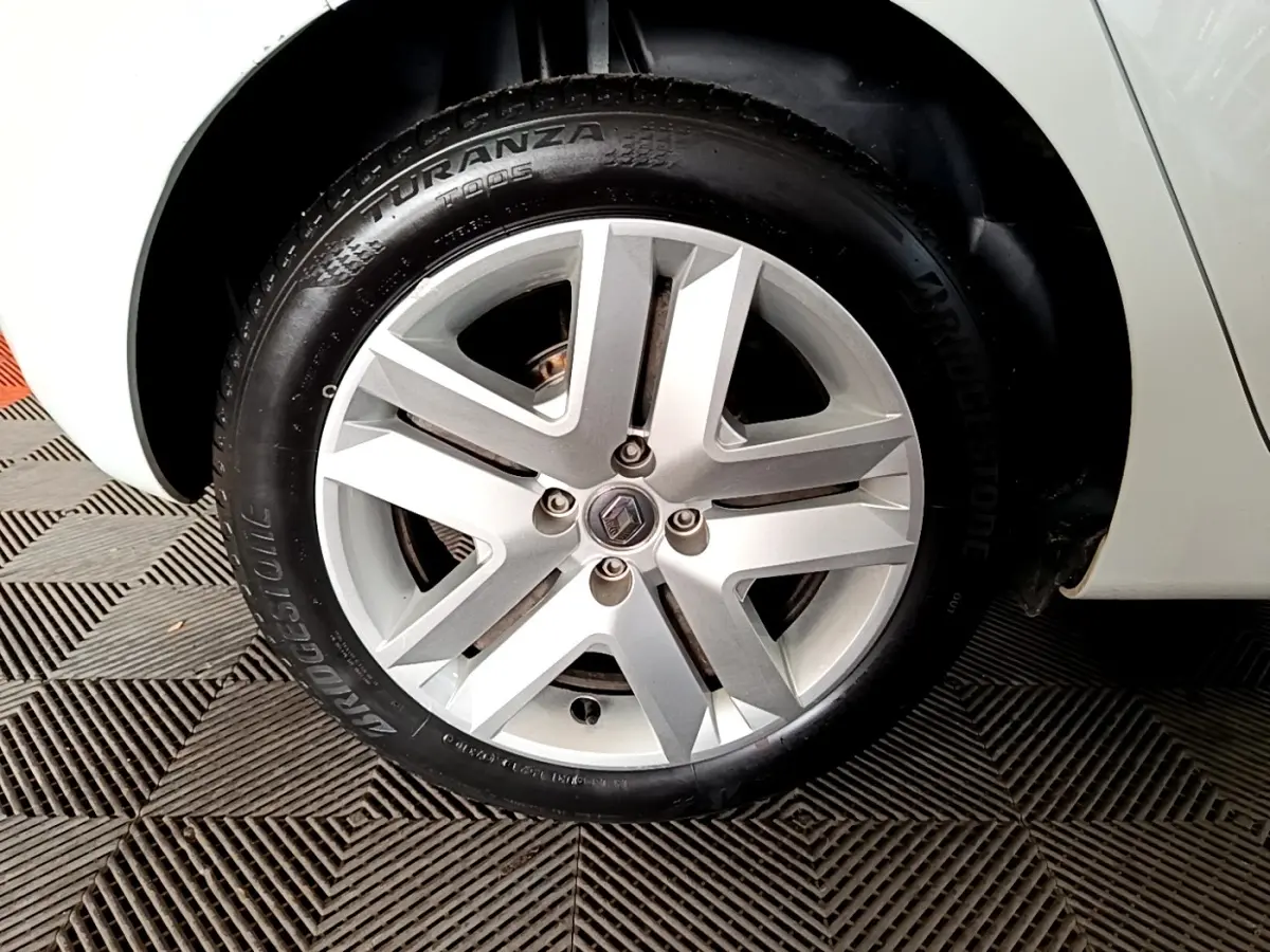 Gros plan sur la roue avant droite d'une Renault Clio blanche, avec jante alliage et pneu Bridgestone Turanza.