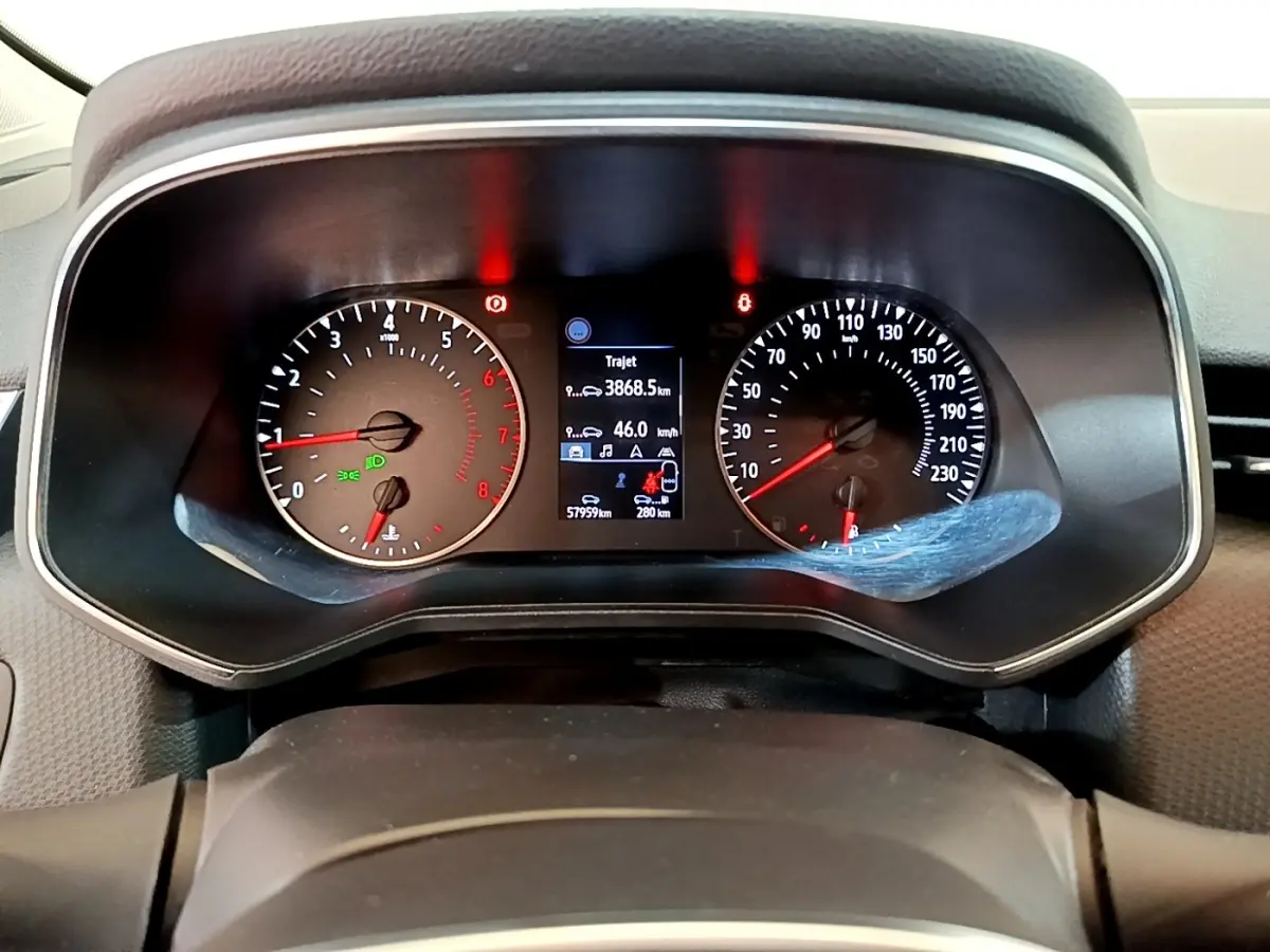 Vue rapprochée du tableau de bord de la Renault Clio Business blanche, affichage numérique et compte-tours analogiques.