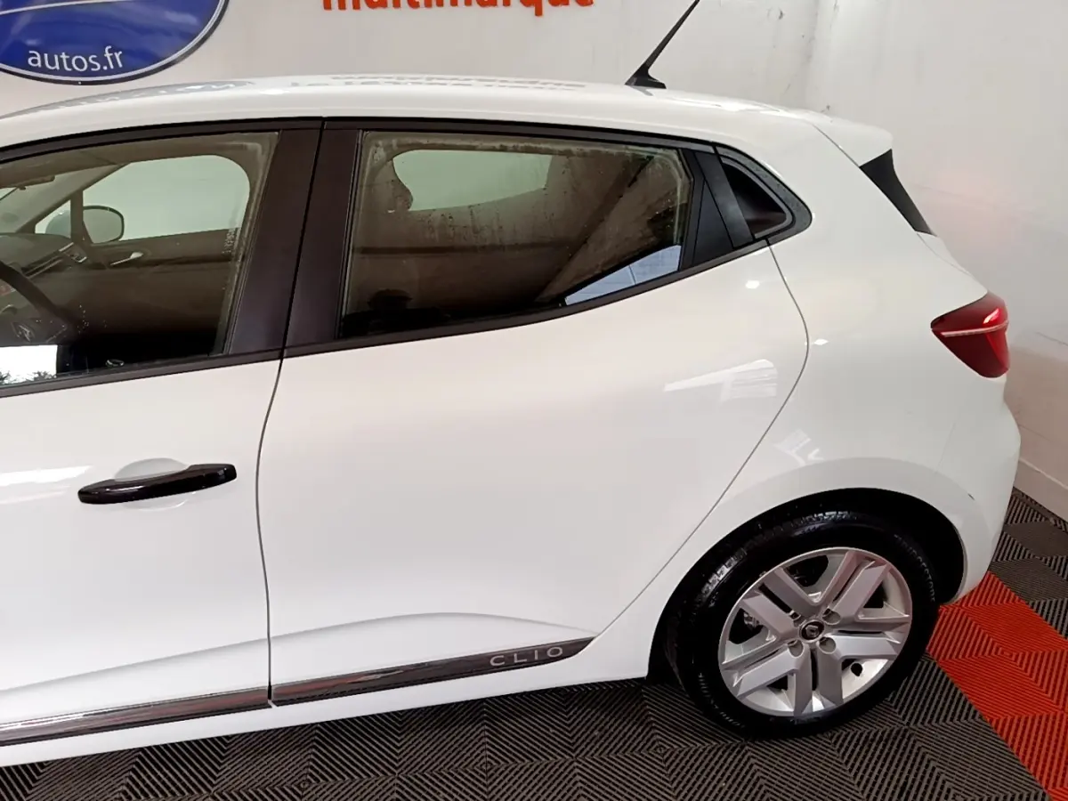 Profil côté gauche de la Renault Clio blanche Business SCe 65 2021, avec jantes alliage et poignées noires.