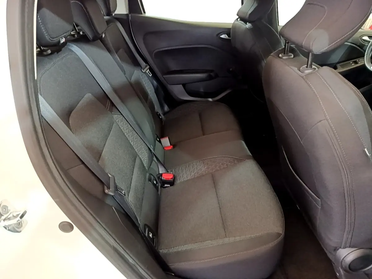 Vue intérieure côté gauche montrant la banquette arrière noire et les sièges avant du Renault Clio Business blanc.