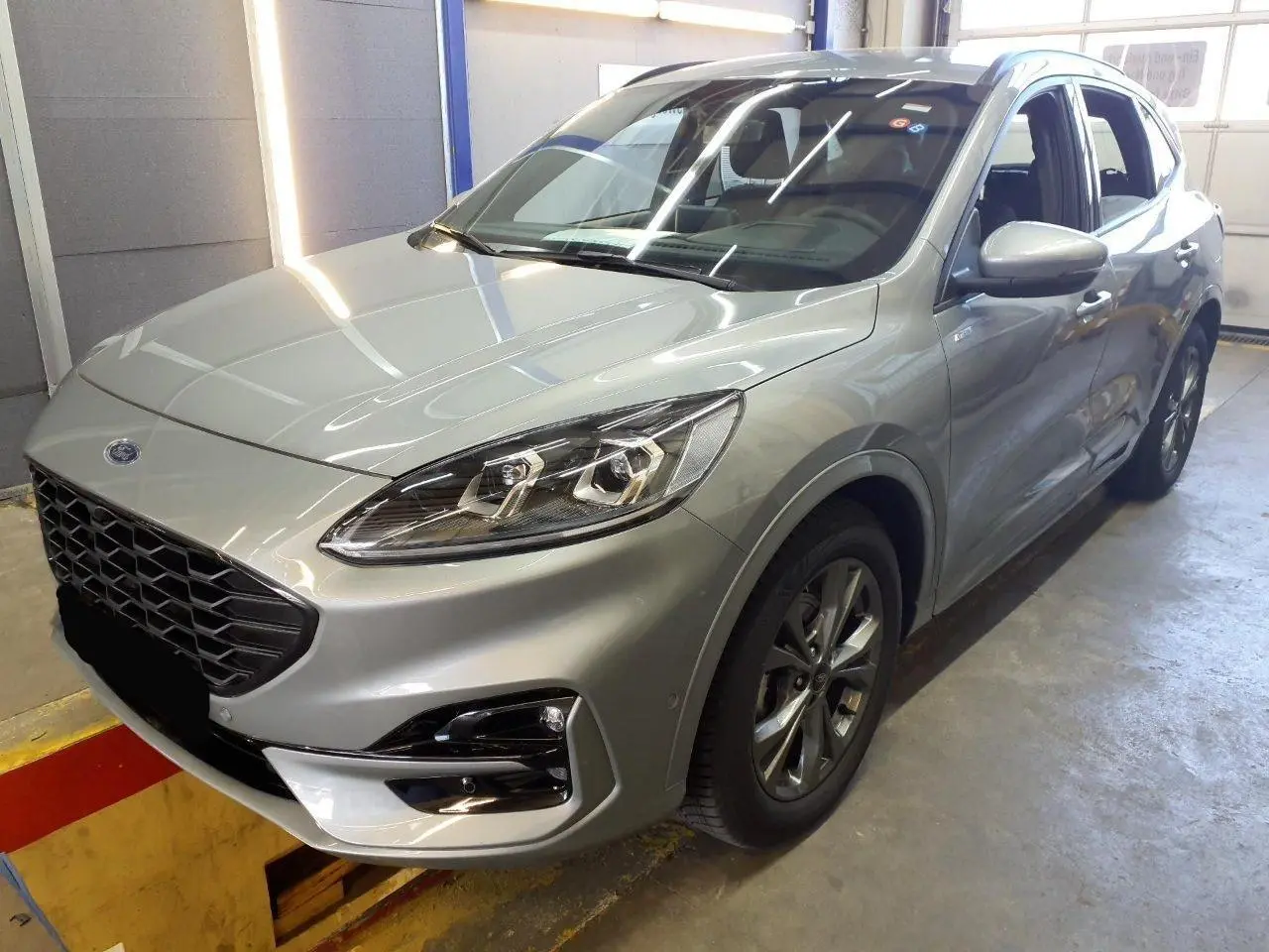 Vue 3/4 avant droit du Ford Kuga 2.0 EcoBlue gris Solar avec calandre noire et jantes alliage 18 pouces.