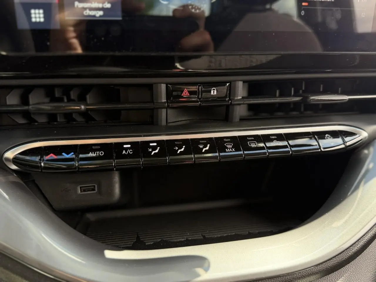 Gros plan sur la console centrale noire du Fiat 500 électrique 2024, mettant en valeur les commandes de climatisation et ventilation.