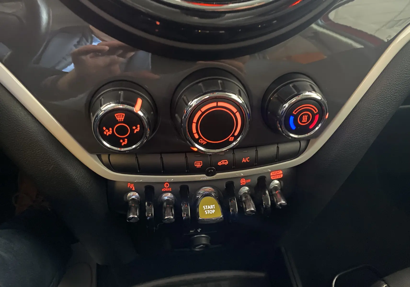 Gros plan sur la console centrale du MINI Countryman rouge toit noir 2018, montrant les commandes climatisation et bouton start/stop.