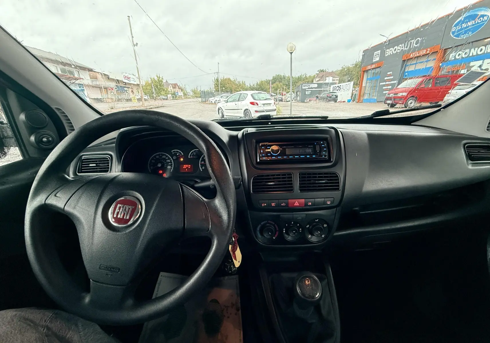 Vue intérieure du tableau de bord et volant du Fiat Doblo Cargo 2011, avec levier de vitesse manuel visible.