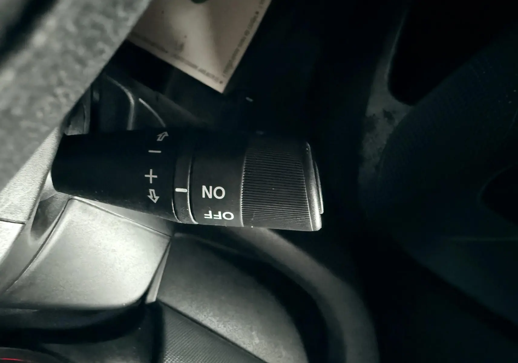 Gros plan sur la commande de clignotant et régulateur de vitesse du FIAT Doblo Cargo 2011, intérieur noir.