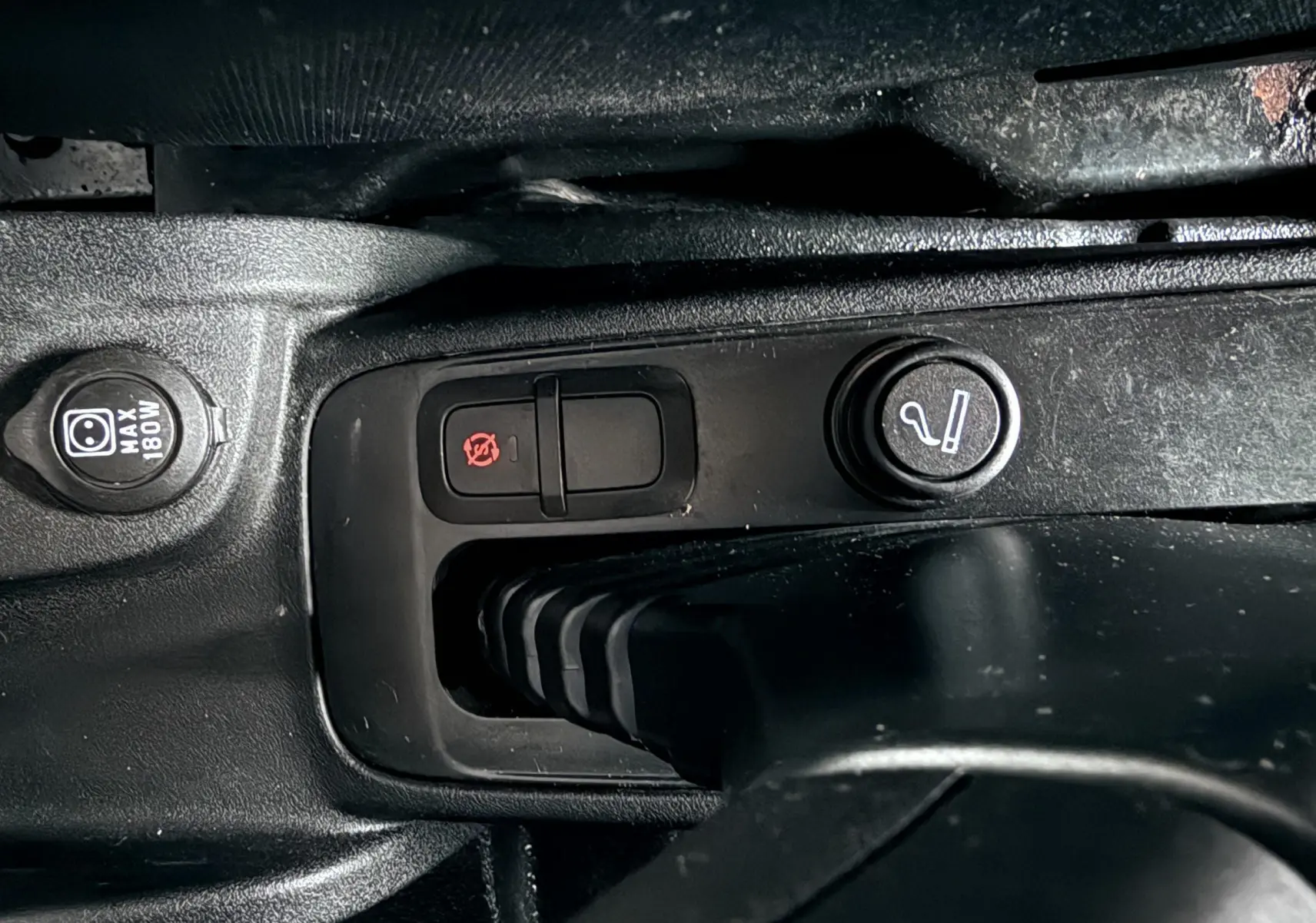 Gros plan sur la console centrale noire du Fiat Doblo Cargo 2011, montrant les boutons de commande et prise 12V.