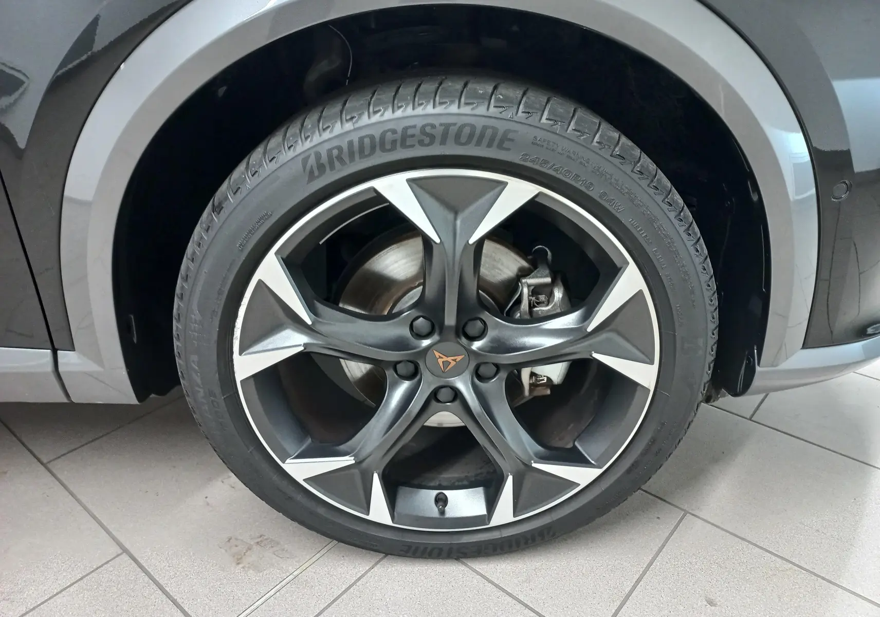 Gros plan sur la roue avant droite du CUPRA Formentor Noir Minuit avec jante en alliage et logo CUPRA central.