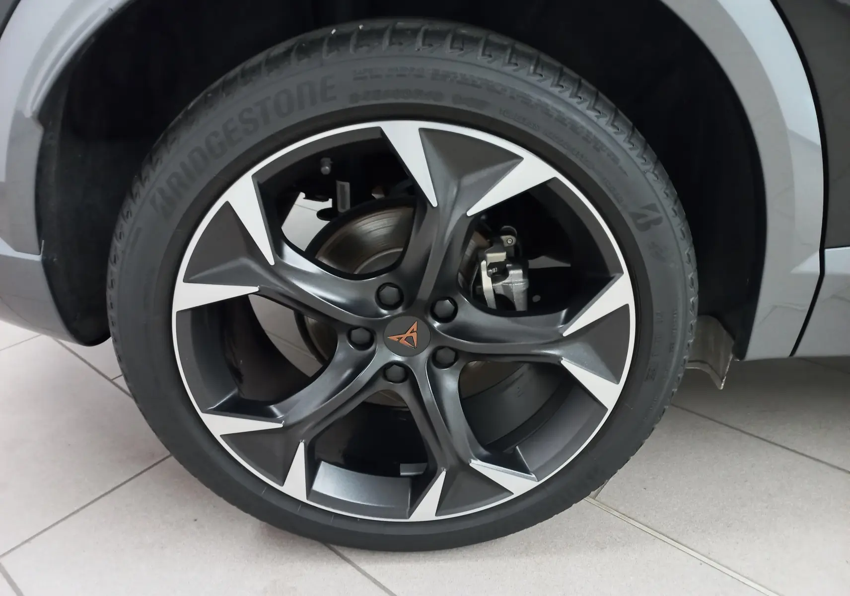 Gros plan sur la roue avant droite du CUPRA Formentor Noir Minuit avec jante alliage au design sportif bicolore.