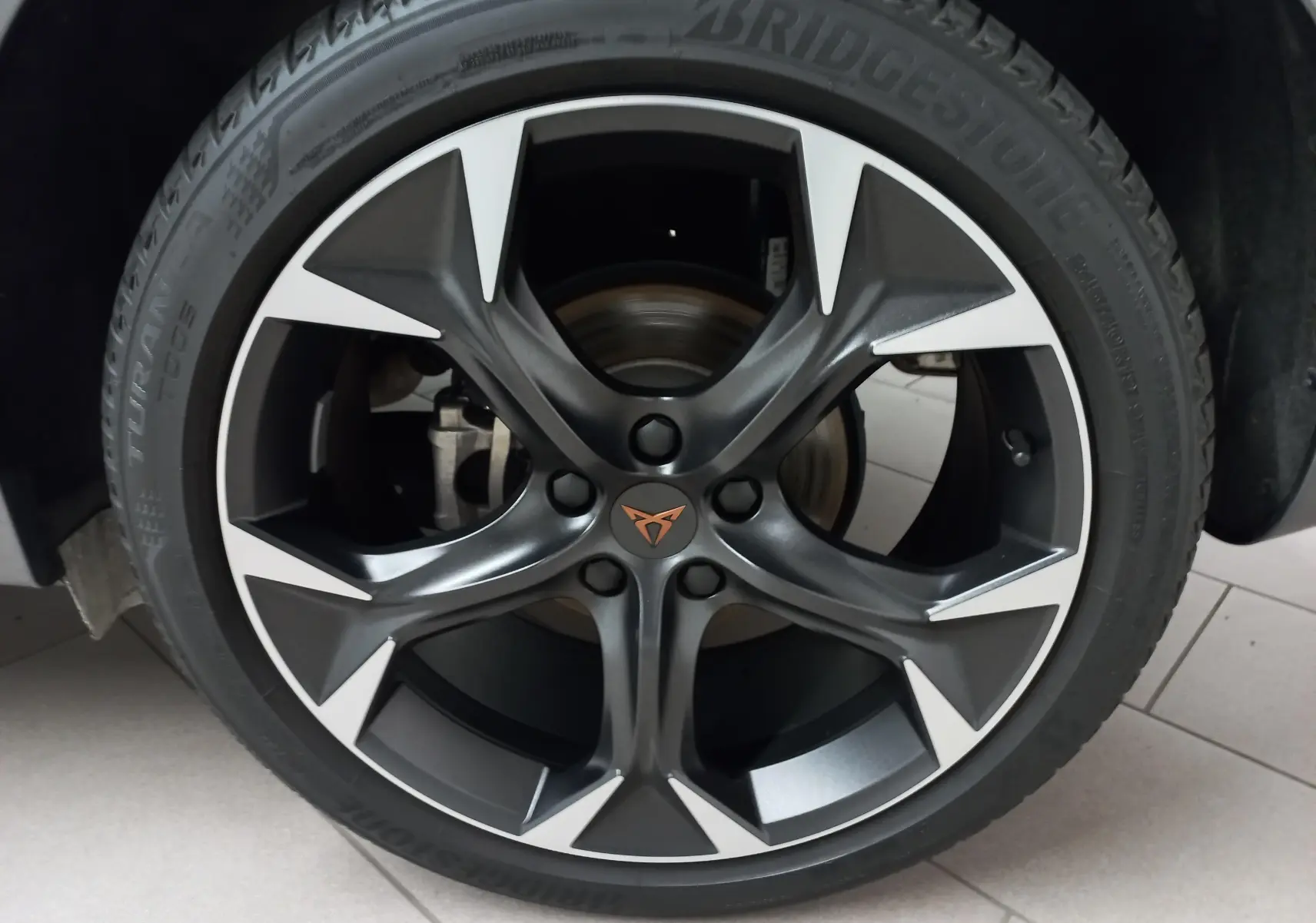 Gros plan sur la jante alliage noire et argentée avec logo CUPRA orange du Formentor Noir Minuit 2023.