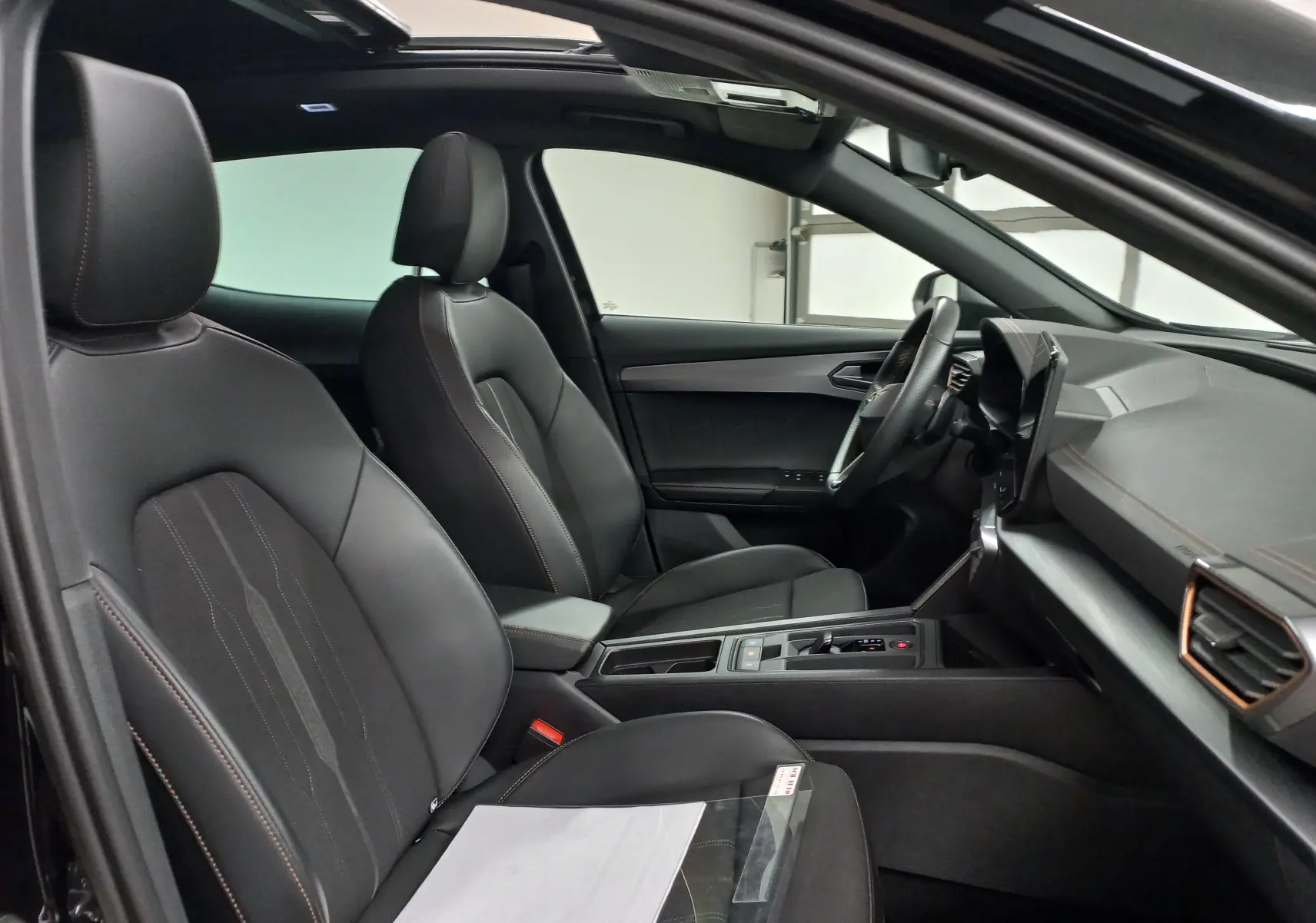 Intérieur avant du CUPRA Formentor noir minuit 2023, sièges cuir noirs avec surpiqûres contrastées et tableau de bord moderne.