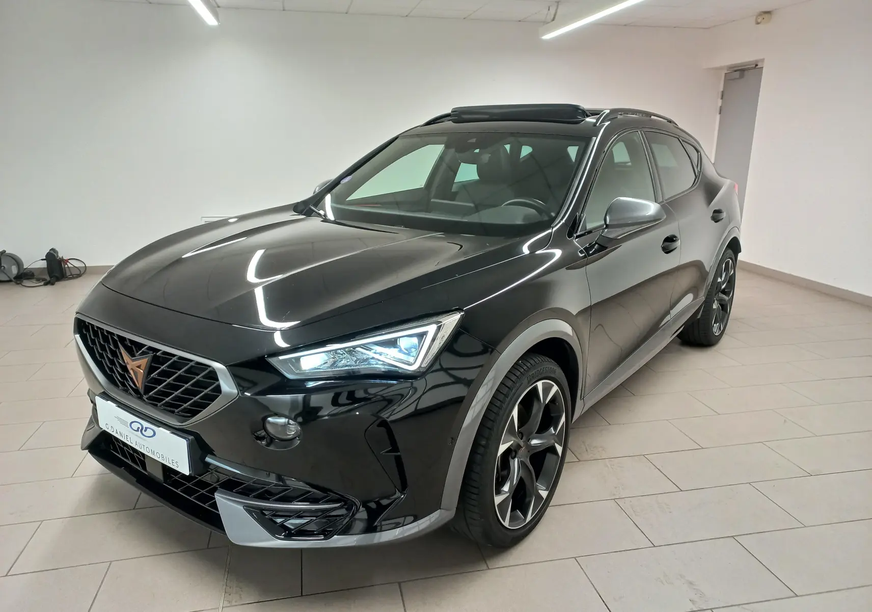 Vue 3/4 avant du CUPRA Formentor 1.5 TSI VZ-LINE noir minuit, avec jantes noires et toit ouvrant panoramique.