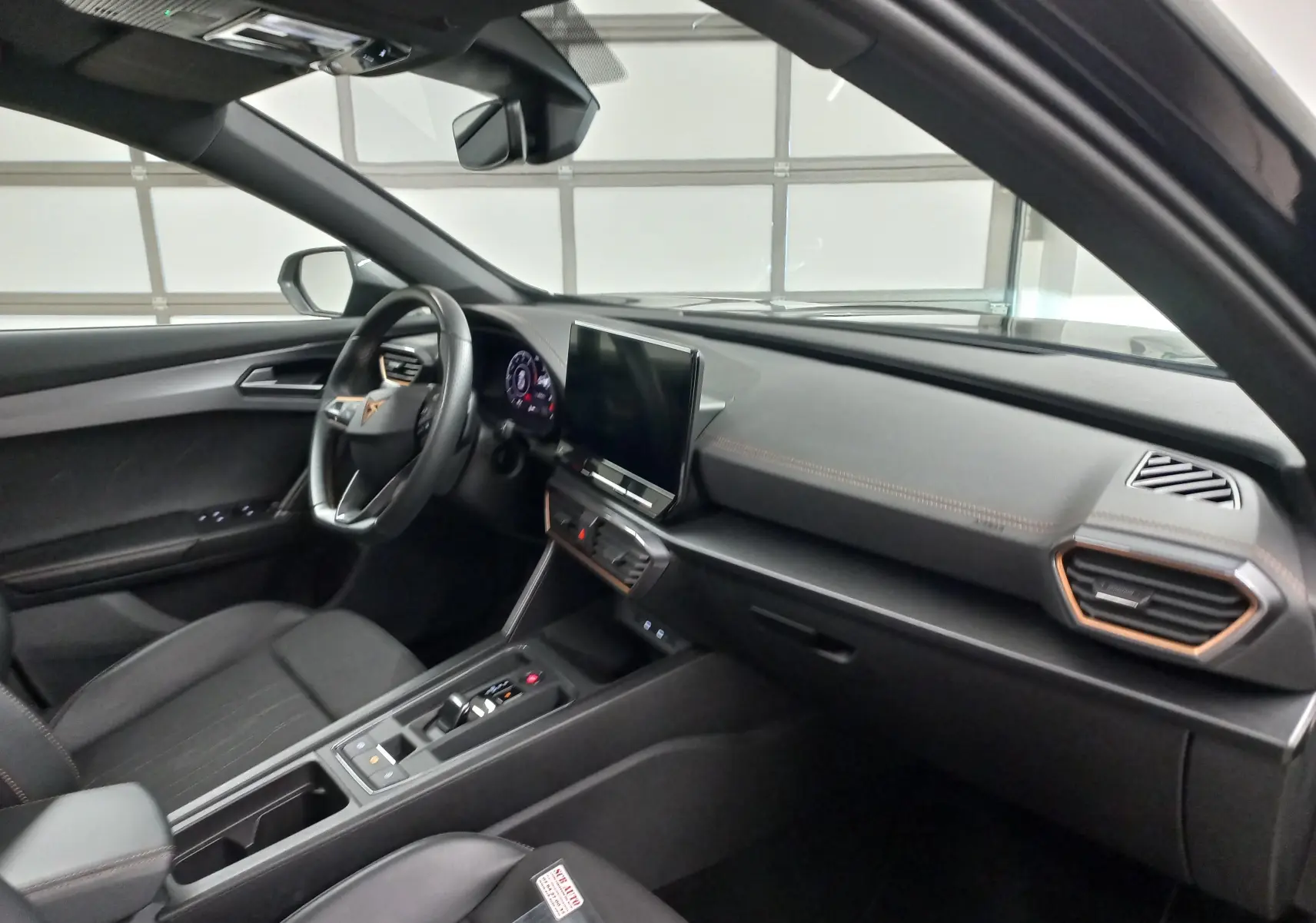 Intérieur du CUPRA Formentor 1.5 TSI 2023 vu côté conducteur, tableau de bord noir avec écran tactile central.