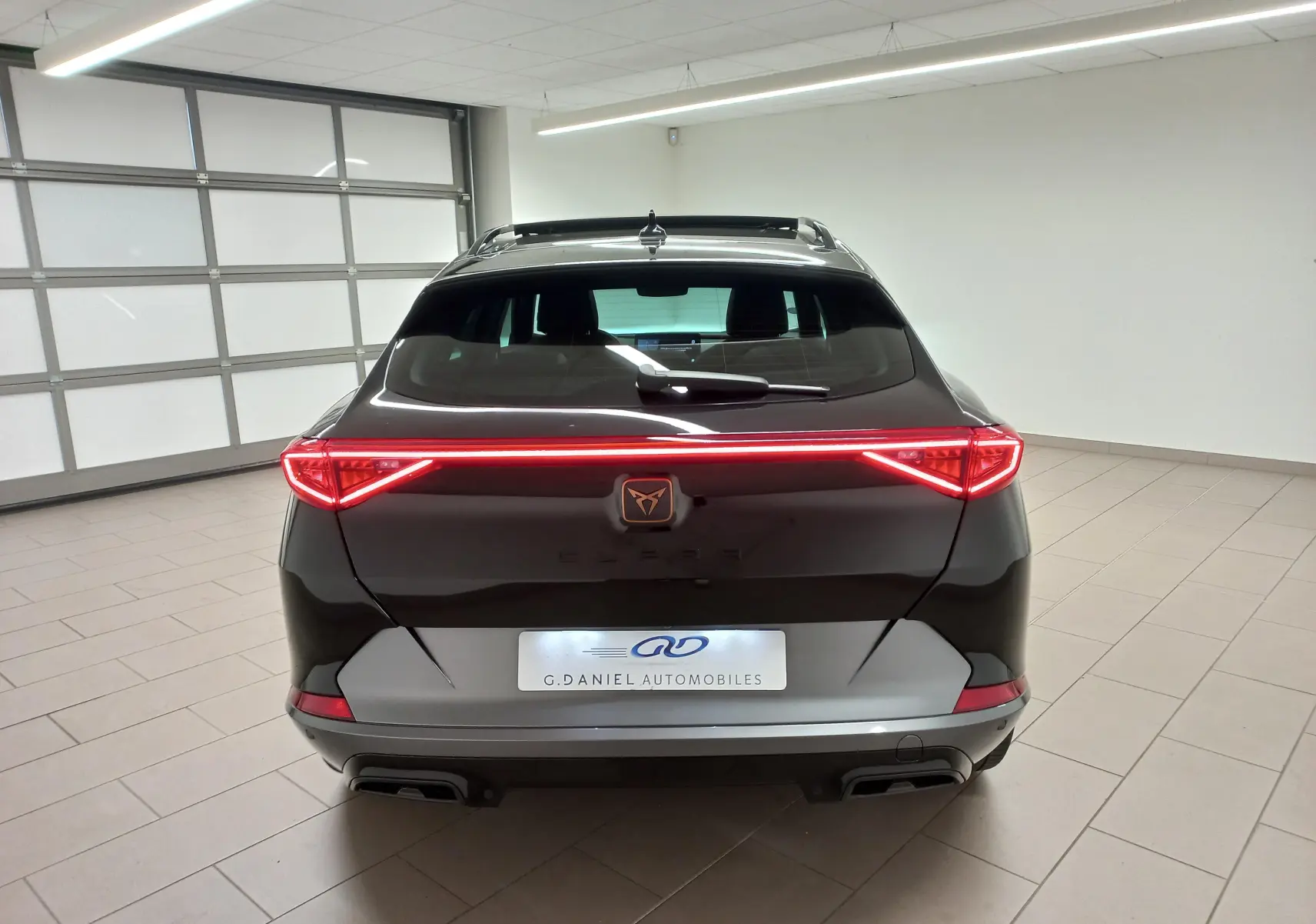 Vue arrière d'une CUPRA Formentor 2023 noir minuit avec feux LED en bandeau et double sortie d'échappement intégrée.