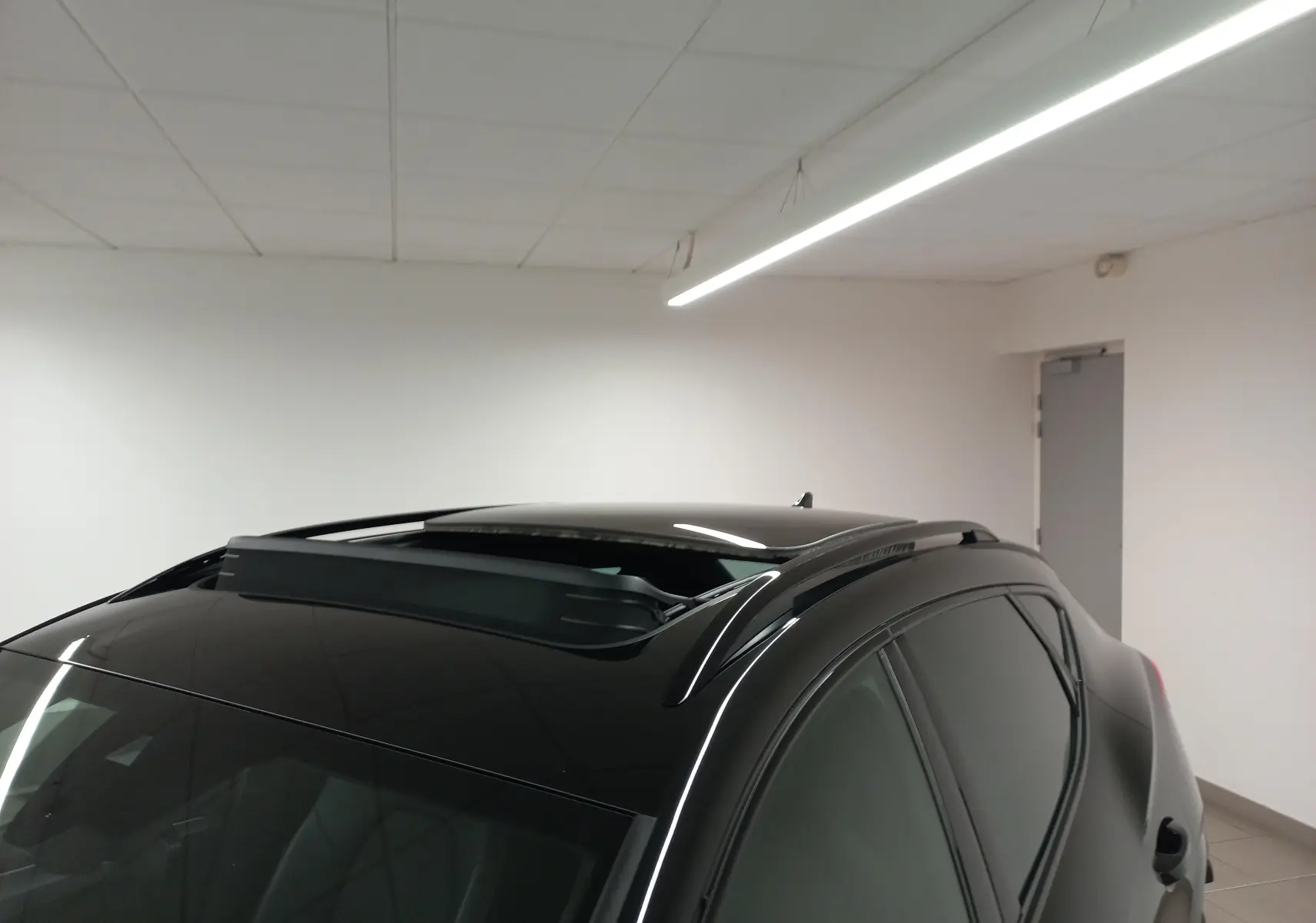 Toit ouvrant panoramique ouvert sur le côté gauche d'un CUPRA Formentor Noir Minuit en intérieur.