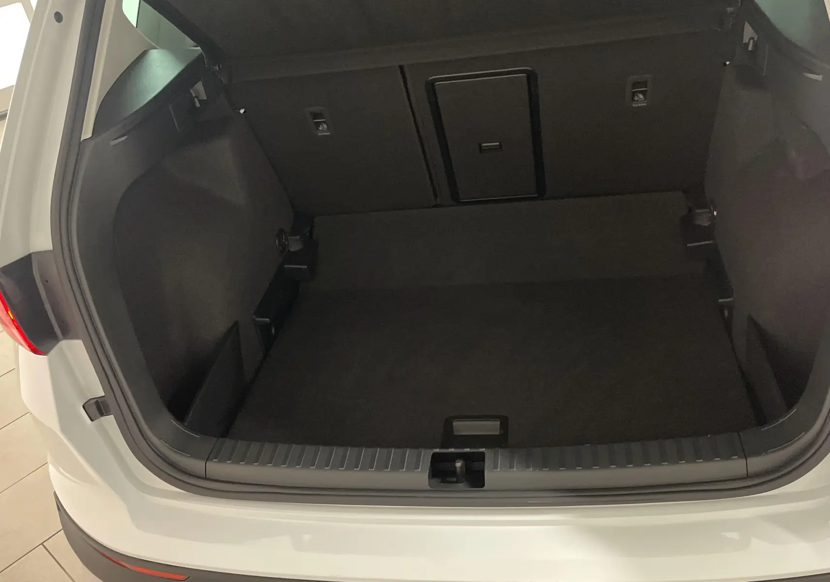 Coffre ouvert vu de l'arrière d'un SEAT Ateca blanc Nevada, soulignant l'espace de chargement vide.
