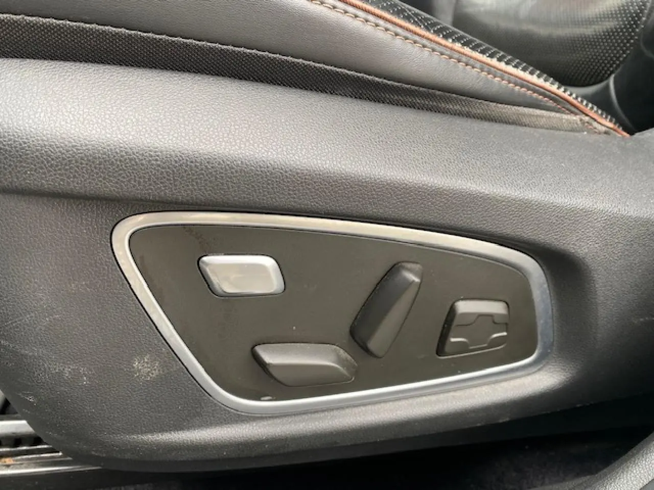 Commandes électriques de réglage du siège conducteur en gros plan dans un Renault Koleos blanc Initiale Paris 2019.