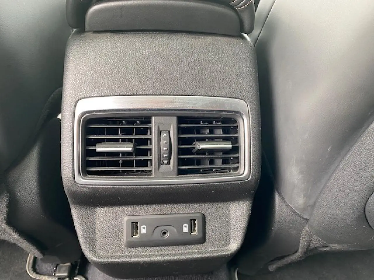 Détail des aérateurs arrière et ports USB noirs dans l'habitacle du Renault Koleos blanc 2019 Initiale Paris.