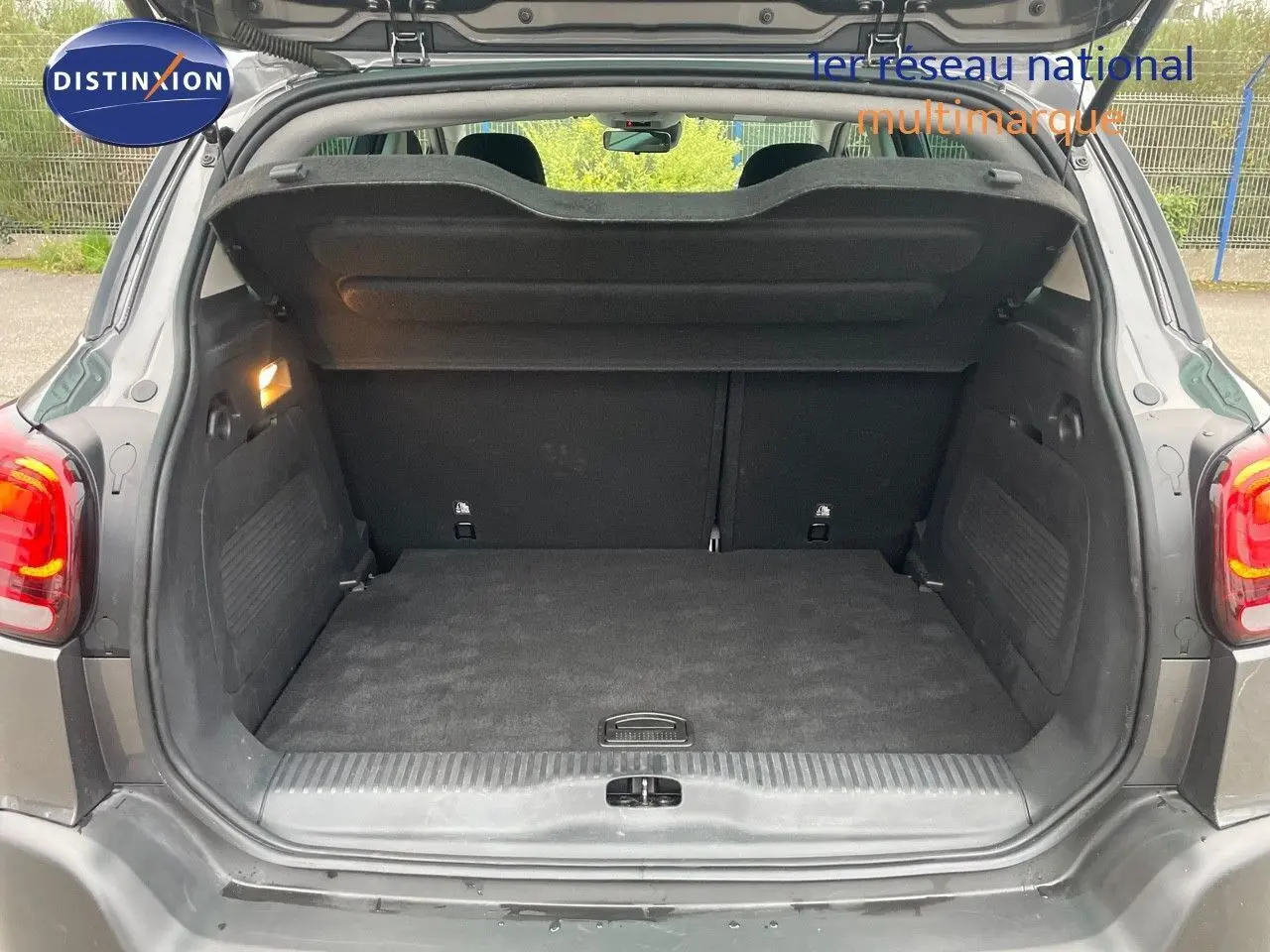 Coffre ouvert vu de l'arrière du Citroën C3 Aircross gris platinium métal, montrant un espace de chargement propre et spacieux.