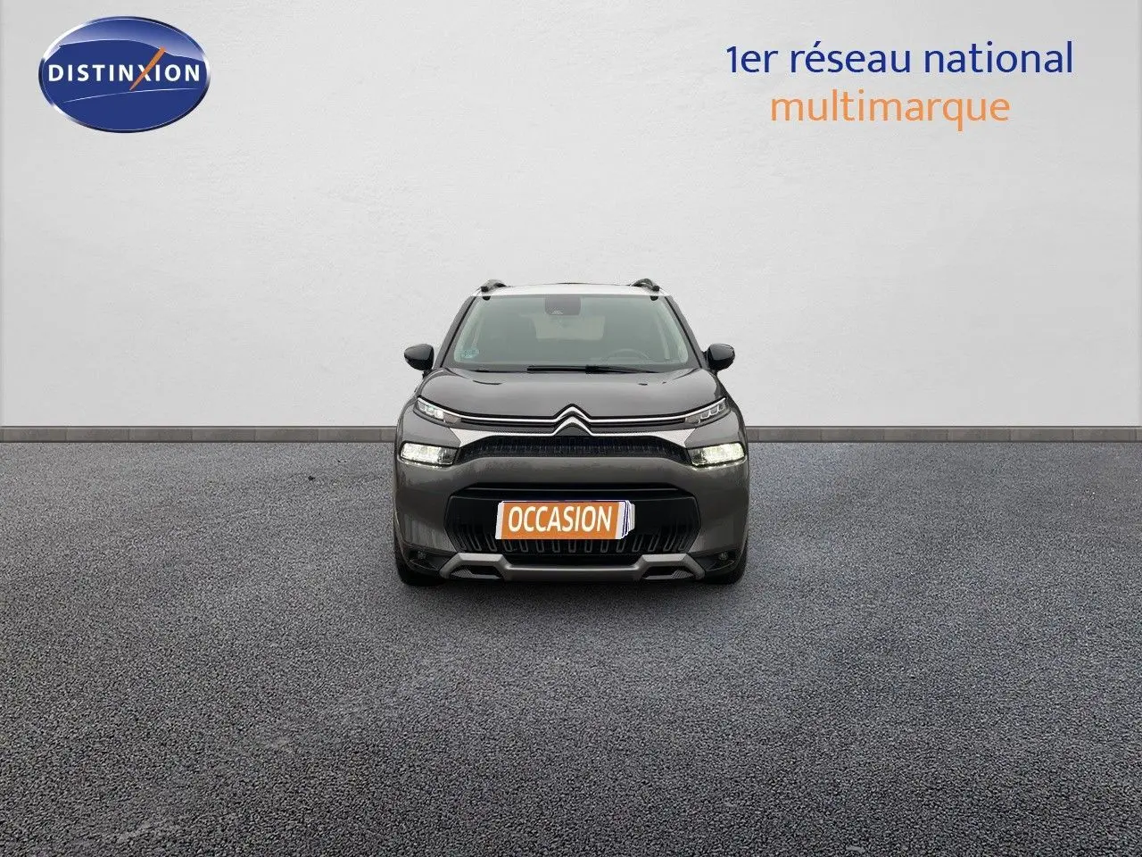 Vue frontale d'un Citroën C3 Aircross gris platinium métal avec plaque "OCCASION" sur un sol gris.