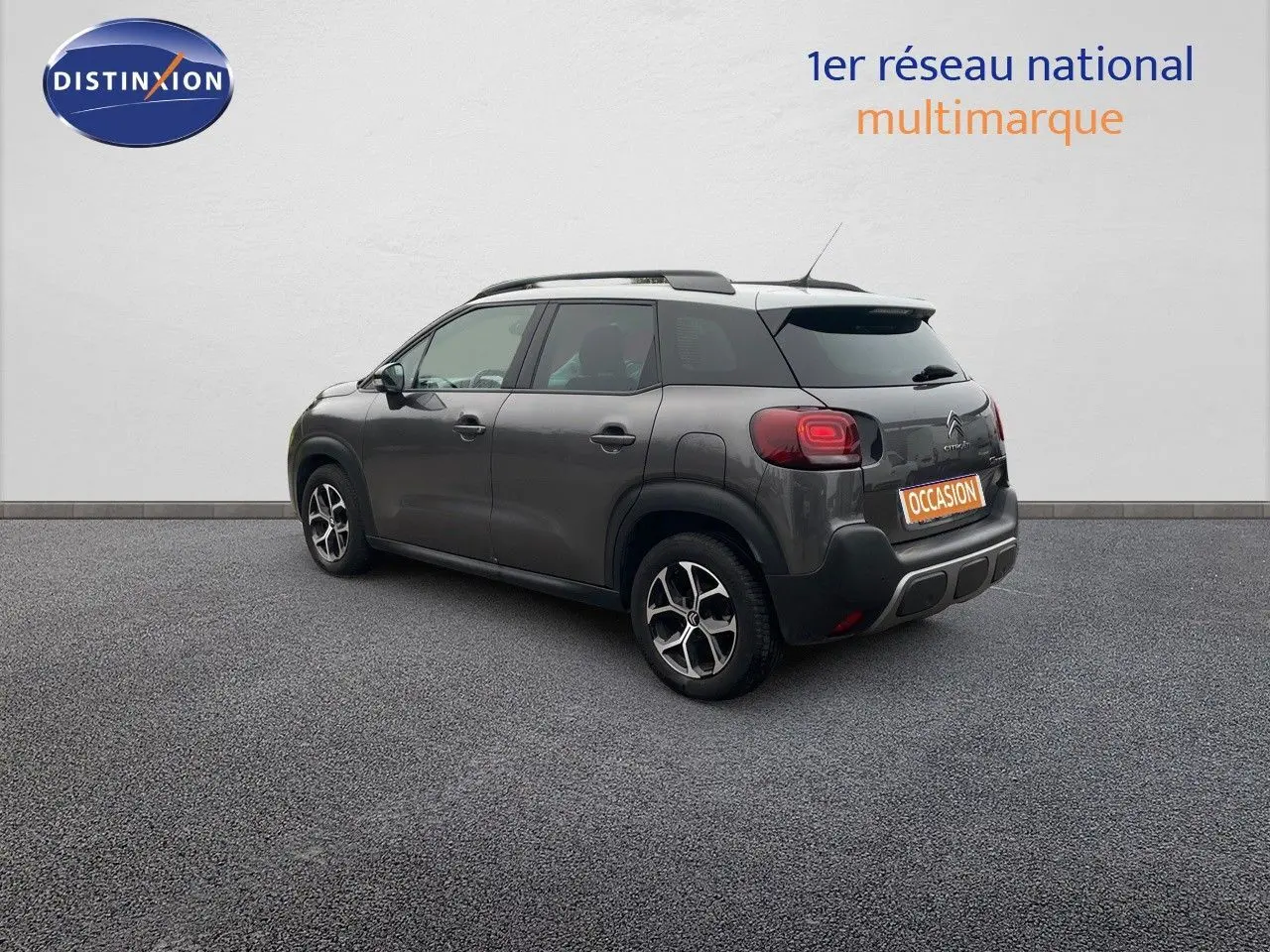 Vue 3/4 arrière droite d'un Citroën C3 Aircross gris platinium métallisé avec jantes bi-ton et toit noir.